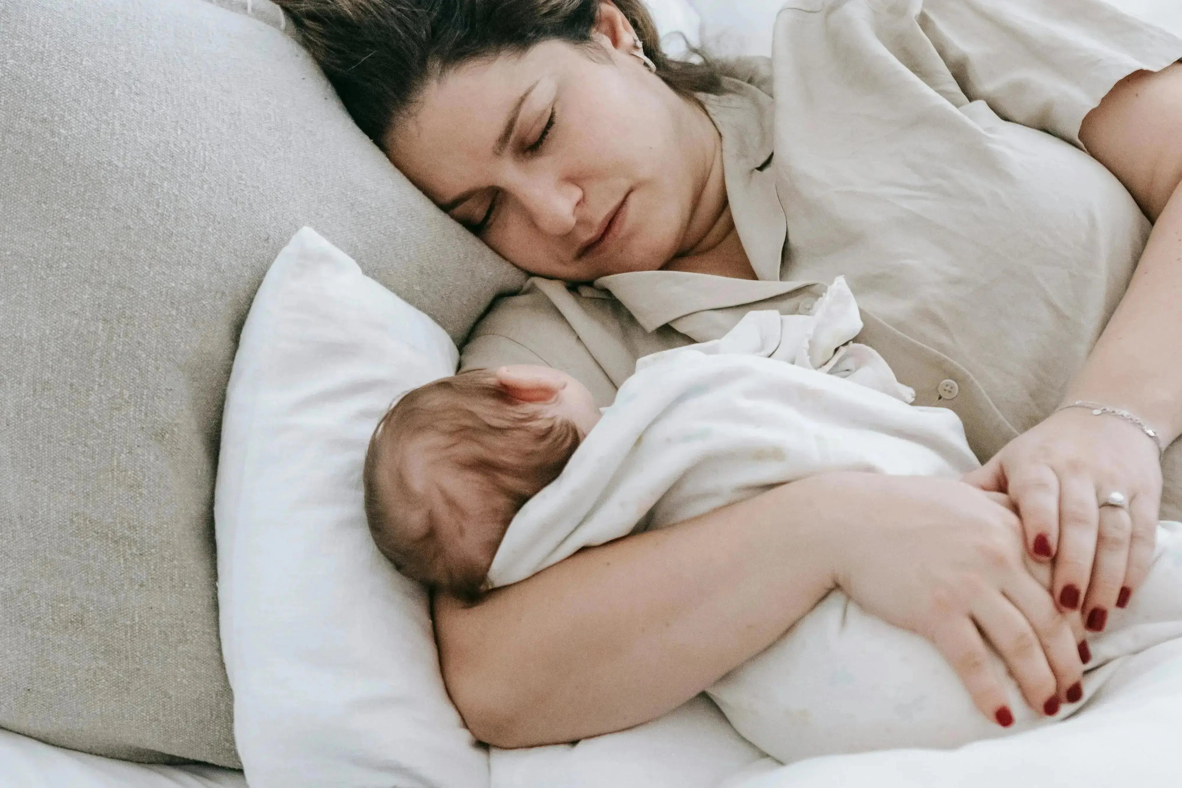 mom and newborn sleeping on bed